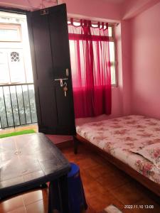 niewielka sypialnia z łóżkiem i oknem w obiekcie AMINA LODGE w mieście Port Blair