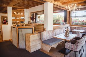 a restaurant with a table and chairs in a room at Hôtel Chalet & Spa Le Delta in Le Grand-Bornand