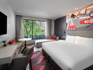 曼谷的住宿－曼谷素坤逸奥克伍德华庭工作室酒店，配有一张床和一张书桌的酒店客房