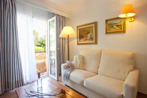 a living room with a couch and a window at Hotel Cala Sant Vicenç - Adults Only in Cala de Sant Vicenc
