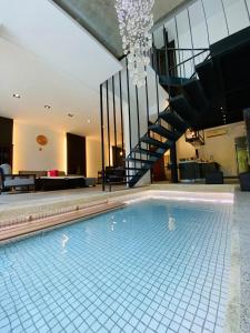 uma grande piscina com uma escada numa casa em Dao Villa em Dongshan