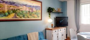 una sala de estar con TV y una pintura en la pared en Casa Pereza, en Trevélez