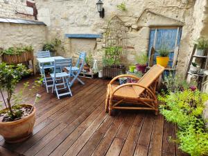 eine Holzterrasse mit Stühlen und einem Tisch darauf in der Unterkunft Superbe maison de caractère, de 1 à 9 couchages in Sainte-Maure-de-Touraine