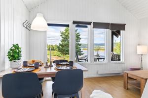 een eetkamer met een tafel en stoelen en een groot raam bij Topcamp Onsakervika - Tyrifjorden in Svensrud
