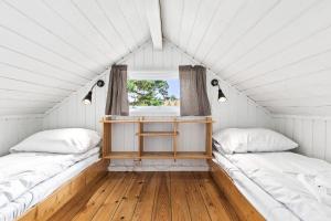 two beds in a white room with a window at Topcamp Onsakervika - Tyrifjorden in Svensrud