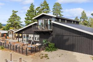 a black house with a balcony on it at Topcamp Onsakervika - Tyrifjorden in Svensrud
