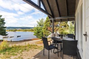 a porch with a table and chairs and a view of a lake at Topcamp Onsakervika - Tyrifjorden in Svensrud