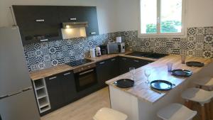 eine Küche mit schwarzen Schränken und einer hölzernen Arbeitsplatte in der Unterkunft Adorable guest house with piscine in Lempaut