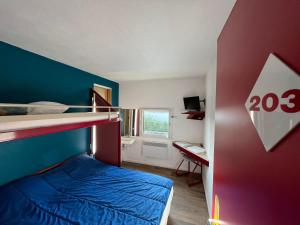 - une chambre avec un lit et un bureau avec une fenêtre dans l'établissement Hotel Eco Blois, à Vineuil