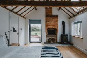 a bedroom with a fireplace and a bed in a room at The Barn in Nottingham