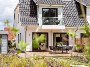 una casa con un patio con mesa y sillas en Meine Schöne 21a, en Fuhlendorf