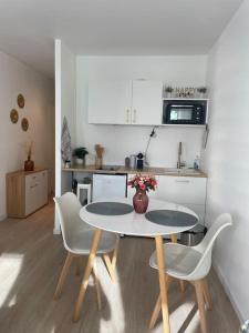 eine Küche mit einem Tisch und Stühlen in der Unterkunft Superbe appartement au cœur de La Défense in Courbevoie