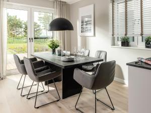 Un comedor con una mesa y sillas negras. en Meine Schöne 21a, en Fuhlendorf