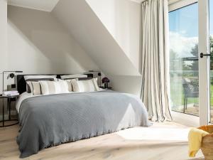 Una habitación blanca con una cama y una ventana en Meine Schöne 21a, en Fuhlendorf