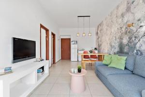 a living room with a blue couch and a tv at Design Apartments by the Beach in TLV in Tel Aviv