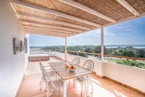 un patio con tavolo e sedie in legno sul balcone. di Cas Saliners - Ses Illetes a La Savina