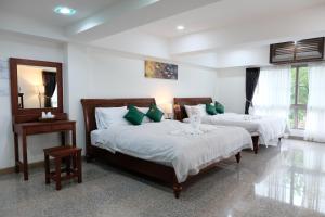 a bedroom with two beds with green pillows at Cha Li's Family Hotel&Hostel in Pai