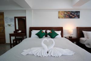 拜縣的住宿－Cha Li's Family Hotel&Hostel，卧室配有天鹅装饰,位于床上