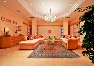 a large living room with couches and a chandelier at Hotel Akazienhaus in Herzogenaurach