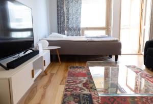 een woonkamer met een bed en een televisie bij 2ndhomes Luxury Kamppi Center Apartment with Sauna and Terrace in Helsinki