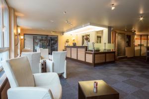 a waiting room with white chairs and a counter at Hotel Amaris in Olten