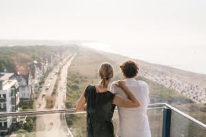 a man and woman standing on a balcony looking at a road at aja Warnemünde in Warnemünde