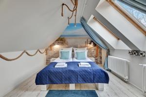 a bedroom with a blue bed in a attic at Sopot Beach & Park Penthouse by Downtown Apartments in Sopot