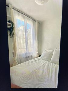 - une chambre avec un lit blanc et une fenêtre dans l'établissement Cute one bedroom in Le Marais, à Paris