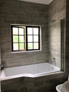 a bathroom with a bath tub and a window at Phil's Country Loft- Power backup in Johannesburg