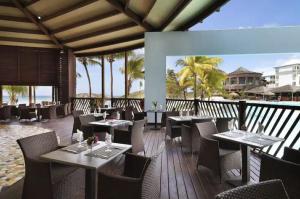 un ristorante sulla spiaggia con tavoli e sedie di Archipel - Cocon d'une architecte en Guadeloupe a Saint-François