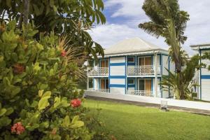 una casa blu e bianca con una palma di Archipel - Cocon d'une architecte en Guadeloupe a Saint-François