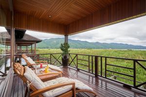 a porch with chairs and a view of a field at KMA Inle Hotel in Nyaung Shwe