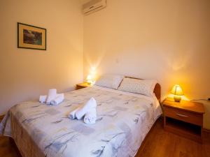 Apartments Torina في باشمان: غرفة نوم عليها سرير وفوط