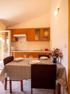 Apartments Torina في باشمان: مطبخ مع طاولة مع كرسيين وطاولة