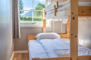 een stapelbed in een kamer met een raam bij Topcamp Havblikk - Helgeland in Nesna