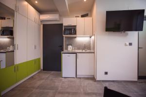 a small kitchen with white cabinets and a tv at DORM BG pet-friendly Aparthotel in Stara Zagora