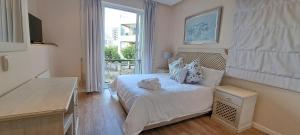 ein kleines Schlafzimmer mit einem Bett und einem Fenster in der Unterkunft V&A Waterfront Marina Family Apartment 101 Altmore in Kapstadt + 45 Fotos