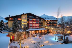 a hotel in the mountains with snow on the ground at Hotel Latini in Zell am See