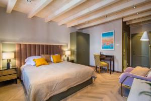 een slaapkamer met een bed met gele kussens en een bureau bij The Melegran in Rovinj