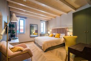 a bedroom with a large bed and a chair at The Melegran in Rovinj
