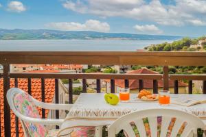 een tafel met een bord fruit en sap op een balkon bij Paramount Apartments in Dugi Rat