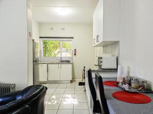 a kitchen with a table and chairs in a room at House of Grace Apt in East London
