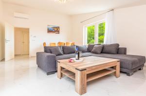 een woonkamer met een bank en een salontafel bij Paramount Apartments in Dugi Rat