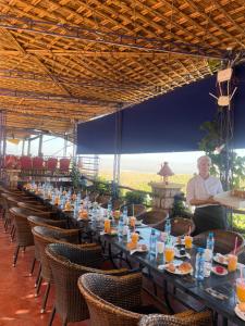 Ein Mann, der an einem langen Tisch mit Essen sitzt. in der Unterkunft maison d'hôtes yamine in Beni Mellal