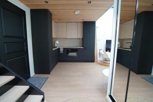 an open kitchen with black walls and wooden floors at Levillas Utsunkulma 10B in Levi