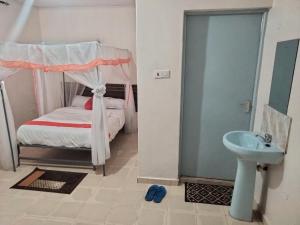 ein kleines Schlafzimmer mit einem Bett und einem Waschbecken in der Unterkunft Good Morning Hotel Rongo in Paulo