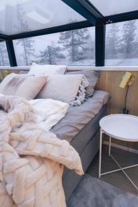 Bett in einem Zimmer mit einem großen Fenster in der Unterkunft Levillas Utsunkulma 10B in Levi