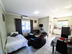 a bedroom with a bed and a couch in a room at House of Grace Apt in East London