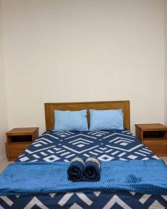 ein Bett mit zwei Paar Schuhen darüber in der Unterkunft Calliandra Homestay in Banyuwangi