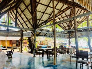 a large wooden pavilion with tables and chairs at Sanctuary Lanta in Ko Lanta